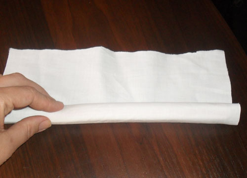 Скручивание белой ткани в трубочку